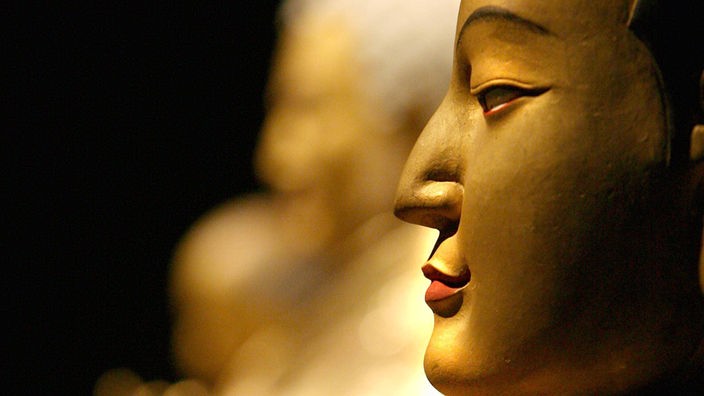 Seitliche Aufnahme des Kopfes einer goldenen Buddhastatue.