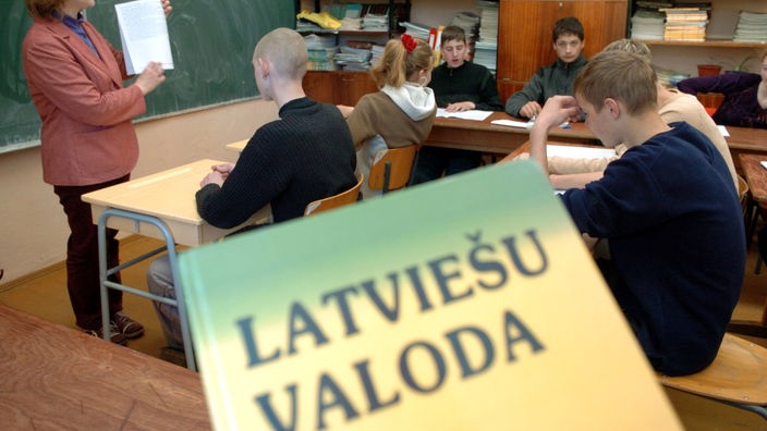 Unterricht in einer lettischen Dorfschule, im Vordergrund das Buch "Latvie&#353;u Valoda".