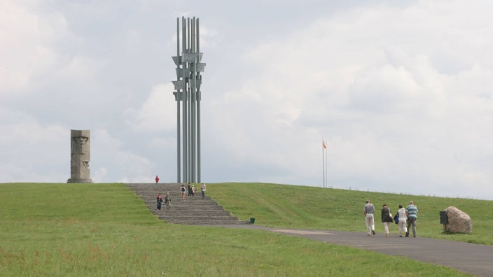 Ein Denkmal aus hohen Pfeilern auf einem weiten Feld.