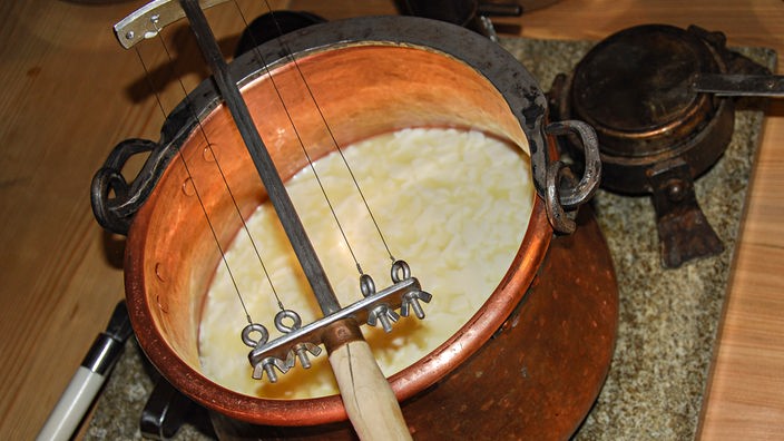 Das Foto wurde in einer Käseschule im Allgäu aufgenommen und zeigt die Herstellung von Käsebruch.
