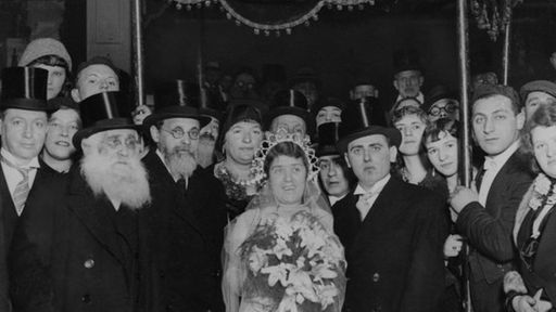 Das Schwarzweiß-Foto zeigt eine jüdische Hochzeitsgesellschaft mit Brautpaar unter dem Baldachin im Jahre 1930 in London.