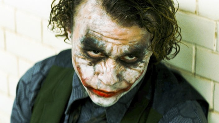 Der Joker: ein Mann mit verschmierter Clownsbemalung.
