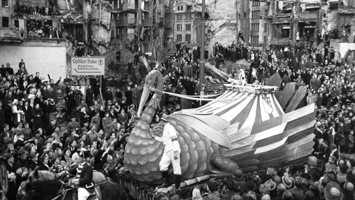 Ein Karnevalswagen fährt 1948 durch die Trümmer der Kölner Innenstadt