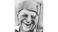 Schwarzweiß-Foto des Clowns Grock mit einer Geige am Kinn