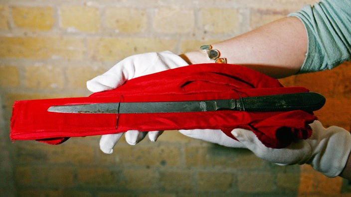 Ein Museumsmitarbeiter hält das original Messer von Jack the Ripper