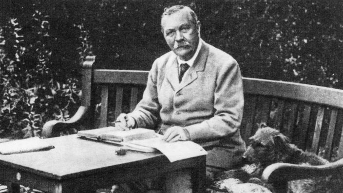Sir Arthur Conan Doyle am Schreibtisch im Garten