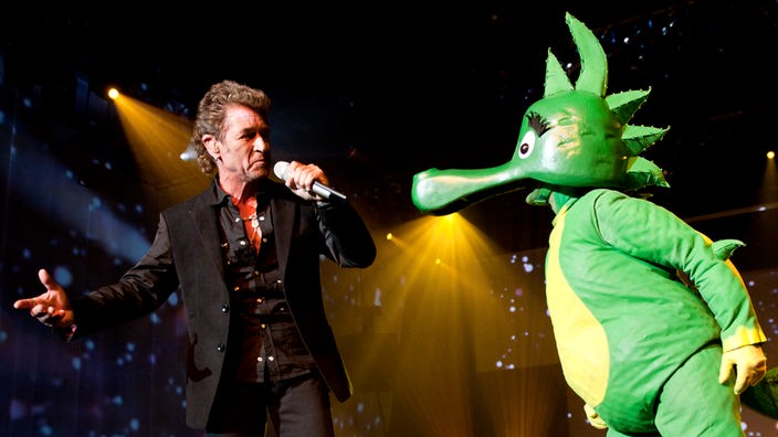 Der Sänger Peter Maffay und der Drache "Tabaluga" auf einer Bühne. 