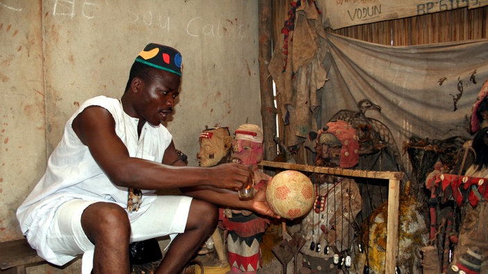 Voodoo-Priester verhext einen Fußball bei einer Zeremonie. | Bildquelle: REUTERS Voodoo-Priester verhext einen Fußball bei einer Zeremonie.
