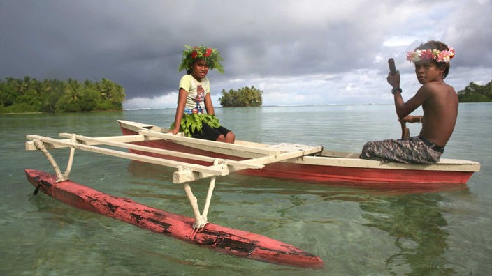 Ein Boot mit zwei Kinder vor der Insel Tuvalu