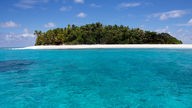 Fidschi-inseln: Türkisfarbenes Wasser und eine Insel mit weißem Sandstrand und Palmen