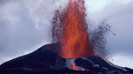 Vulkan spuckt Rauch und Feuer in einer großen Fontäne aus dem Krater.