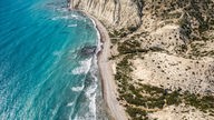 Eine Steilküste mit türkisblauem Meer von oben