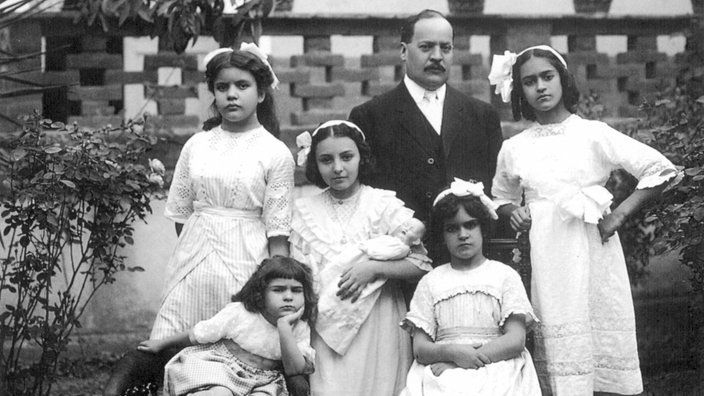 Schwarz-weiß-Fotografie der fünfjährigen Frida Kahlo mit ihren Schwestern Matilde und Adriana, zwei Cousinen und ihrem Onkel vor einer Mauer | Bildquelle: Interfoto / Granger, NYC Schwarz-weiß-Fotografie der fünfjährigen Frida Kahlo mit ihren Schwestern Matilde und Adriana, zwei Cousinen und ihrem Onkel vor einer Mauer
