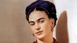 Frida Kahlo mit rotem Schal, weißem Oberteil und Hochsteckfrisur