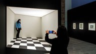 Museumsbesucher in einer begehbaren Installation bei der Escher-Ausstellung in Barcelona 2021
