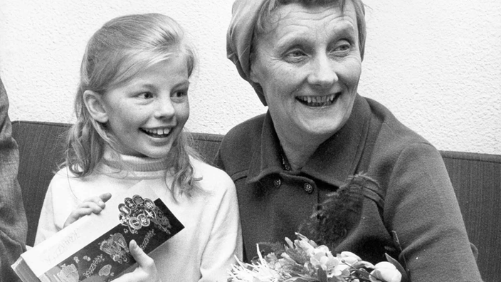 Astrid Lindgren und Inger Nilsson auf einem Sofa. Beide lächeln.