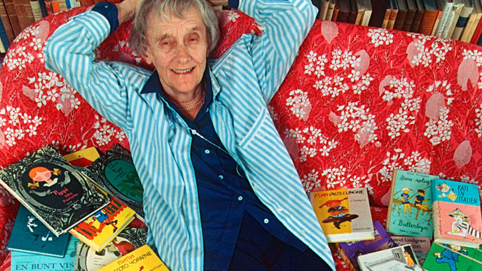 Astrid Lindgren auf einem Sofa, begraben unter Büchern. | Bildquelle: WDR/dpa Picture-Alliance Astrid Lindgren auf einem Sofa, begraben unter Büchern.