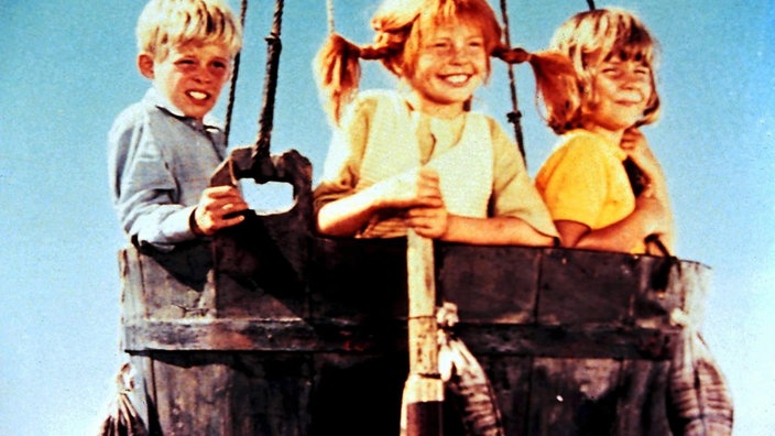Filmszene aus Pippi Lamgstrumpf. Pippi, Annika und Tommi sitzen in einem Ballonkorb. | Bildquelle: ddp Filmszene aus Pippi Lamgstrumpf. Pippi, Annika und Tommi sitzen in einem Ballonkorb.