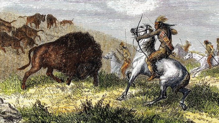 Schnitt aus dem 19. Jahrhundert zeigt Indigene auf Pferden, die mit Pfeil und Bogen Bisons jagen