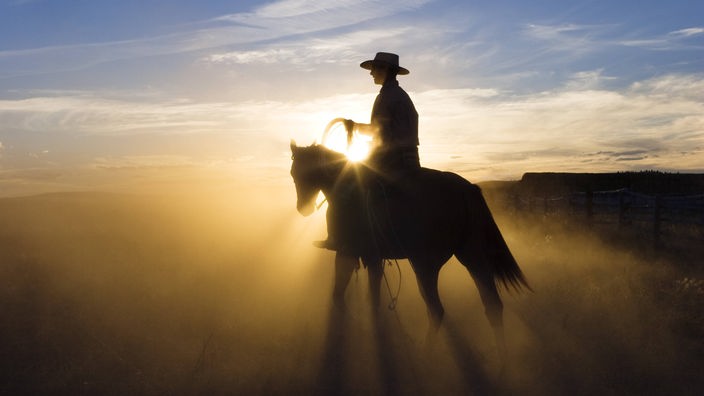 Reiter vor Sonnenuntergang im Mittleren Westen der USA