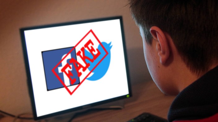 Jugendlicher sitzt am Computer und schaut auf seinen Bildschirm mit Twitter und Facebook Emblemen