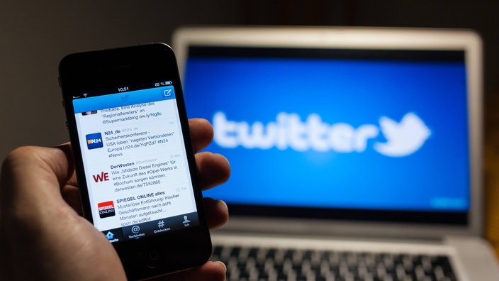 Handy mit diversen Twitter-Meldungen, dahinter Bildschirm mit Twitter-Emblem | Bildquelle: Imago/Rüdiger Wölk Handy mit diversen Twitter-Meldungen, dahinter Bildschirm mit Twitter-Emblem