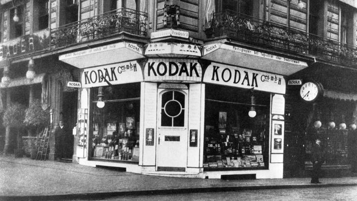 Kodak eröffnet 1896 sein erstes Fotogeschäft in Deutschland an der Ecke Friedrichstr./Unter den Linden. George Eastman gründet seine eigene Gross- und Einzelhandelsfirma für fotografische Produkte in Deutschland, die Eastman Kodak GmbH.