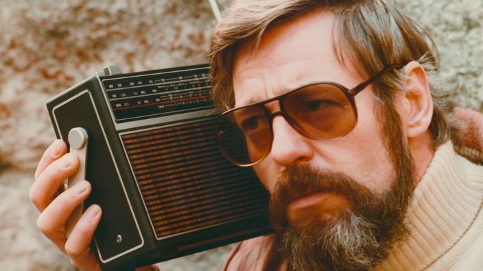 Archivbild: Mann hat Radio auf der Schulter und hört zu