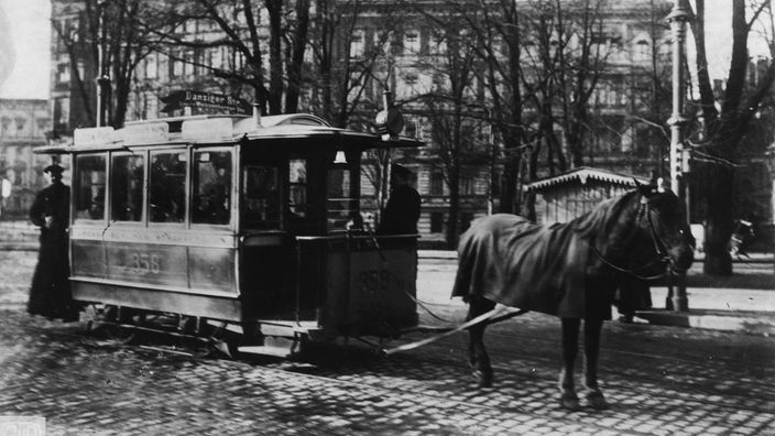 Schwarzweiß-Foto: Ein Straßenbahnwagen um 1900 in Berlin, der von einem Pferd gezogen wird