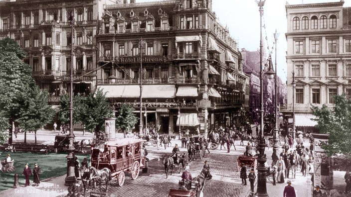 Das Schwarzweiß-Bild aus dem Jahr 1890 zeigt eine belebte Straßenkreuzung mit Kutschen und Fußgängern.