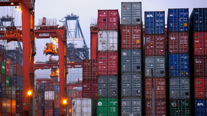 Blick auf ein Containerhafenterminal mit Unmengen von bunten Containern und einigen Lastkränen.