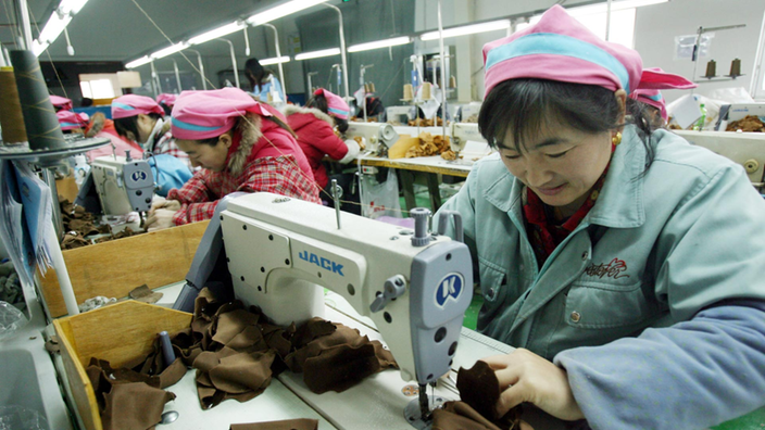 Eine Frau arbeitet an einer Nähmaschine.