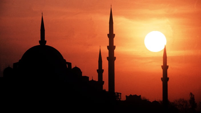 Die Sonne geht hinter den Minaretten der Suleiman-Moschee in Istanbul unter.