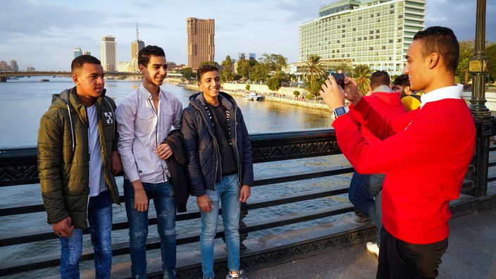 Junge Männer schießen auf einer Brücke in Kairo ein Erinnerungsfoto