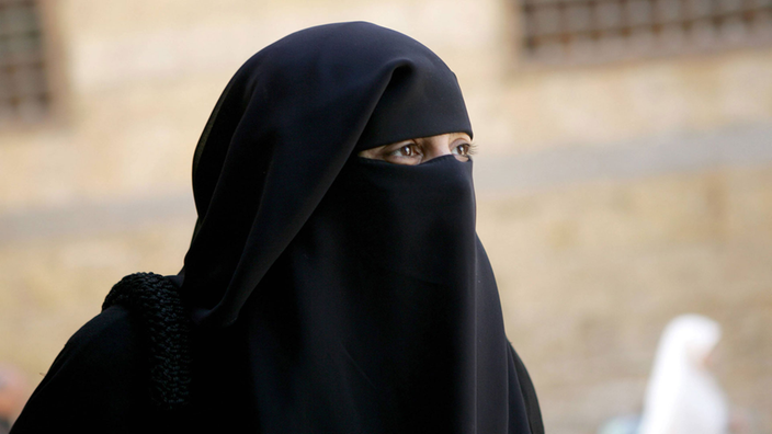 Eine Muslima in Kairos Straßen trägt einen schwarzen Schleier. Nur ihre Augen sind zu sehen.