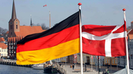 Die Flaggen von Dänemark und Deutschland wehen im dänischen Sonderburg über dem Hafen.