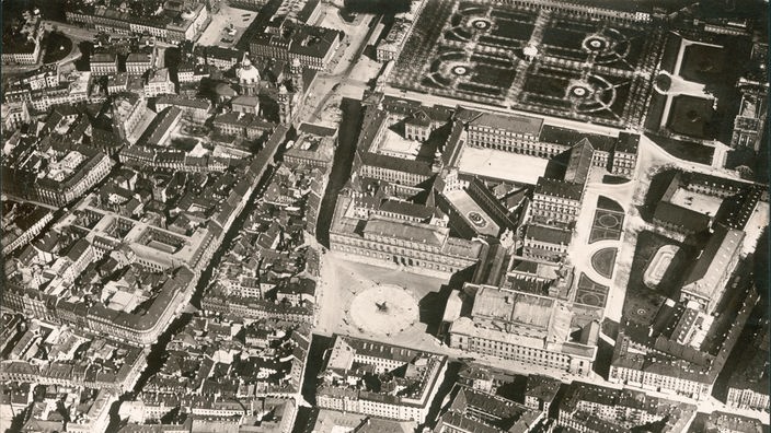 Das Foto zeigt eine Luftaufnahme der Innenstadt Münchens von 1917. Auch die Residenz ist deutlich zu erkennen. In ihrer Mitte liegt der Brunnenhof. Er ist umgeben von weiteren Höfen und Gebäuden.