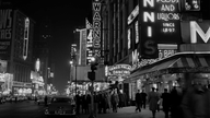Schwarzweiß-Bild: New Yorker Broadway bei Nacht.