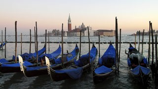 Gondeln im Vordergrund, Venedigs Silhouette im Hintergrund