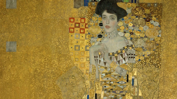 Gemälde von Gustav Klimt: Eine verführerische dunkelhaarige Frau mit einem reich verzierten Kleid vor goldenem Hintergrund. | Bildquelle: akg Gemälde von Gustav Klimt: Eine verführerische dunkelhaarige Frau mit einem reich verzierten Kleid vor goldenem Hintergrund.