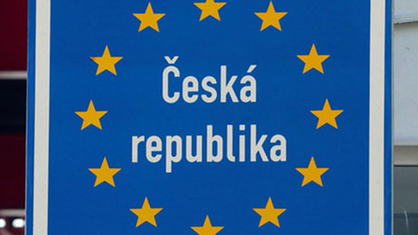 Ein Mann montiert ein EU-Schild an der tschechischen Grenze.