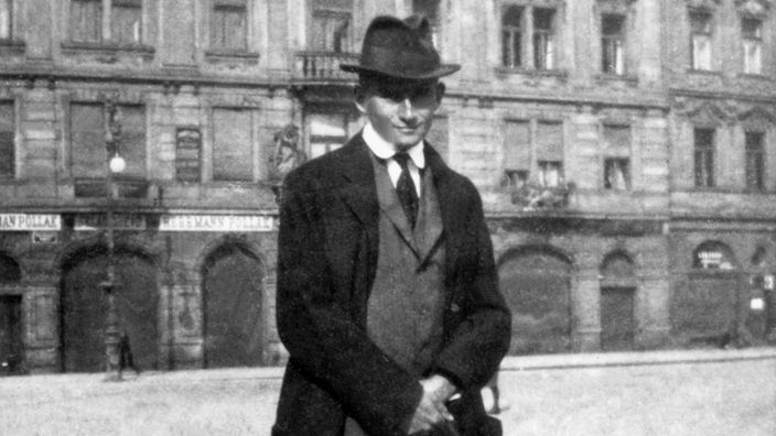 Schwarzweiß-Bild: Franz Kafka mit Anzug und Hut.