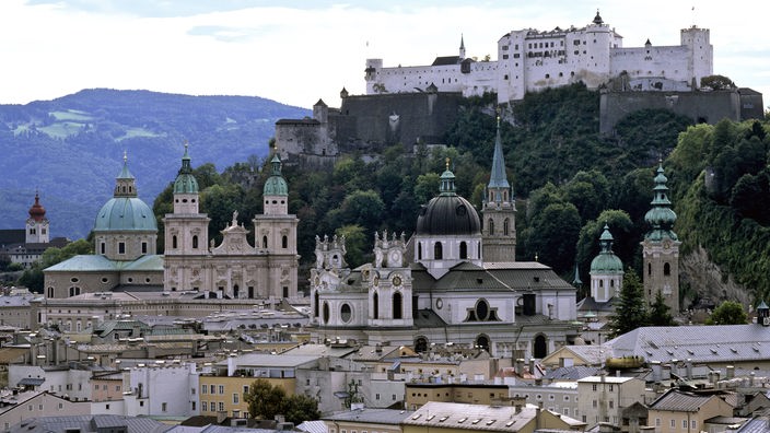 Die Altstadt von Salzburg wird von den Türmen barocker Kirchen überragt. Auf einer Anhöhe die Burg.