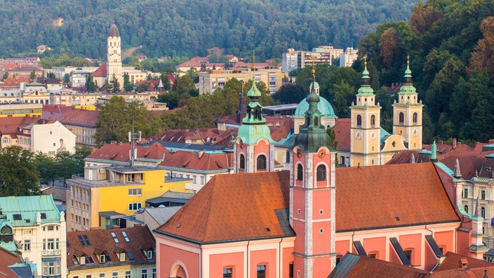 Blick auf die Dächer der Altstadt Ljubljanas, im Vordergrund eine Kirche | Bildquelle: mauritius images / ClickAlps Blick auf die Dächer der Altstadt Ljubljanas, im Vordergrund eine Kirche