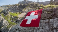 Riesige Schweizer Fahne an einem Berghang