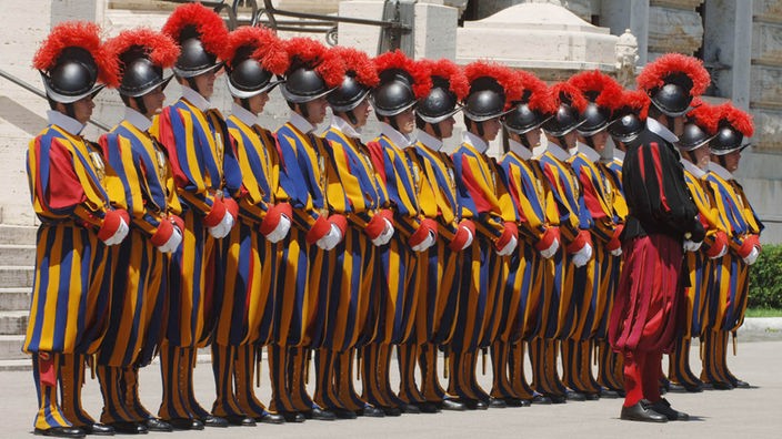 Schweizergarde in blau-rot-gelben Uniformen steht stramm