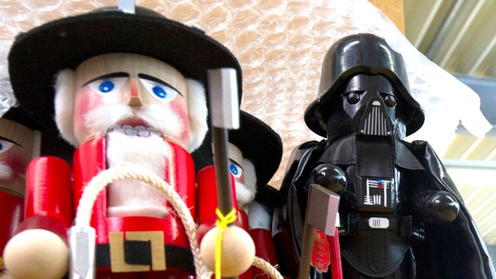 Ein Nussknacker in der Figur von Darth Vader neben einem tradtionellen Männchen