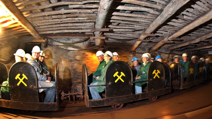 Besucher fahren mit der Grubenbahn durch das Schaubergwerk Röhrigschacht in Sachsen-Anhalt