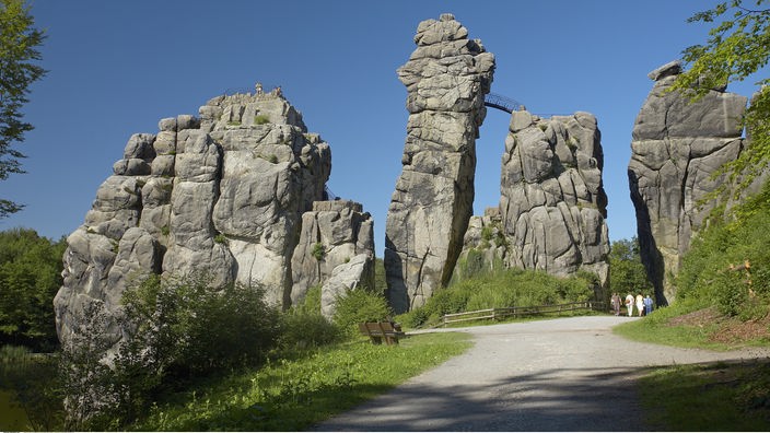 Eine distinkte Felsformation vor blauem Himmel: die Externsteine im Teutoburger Wald. 