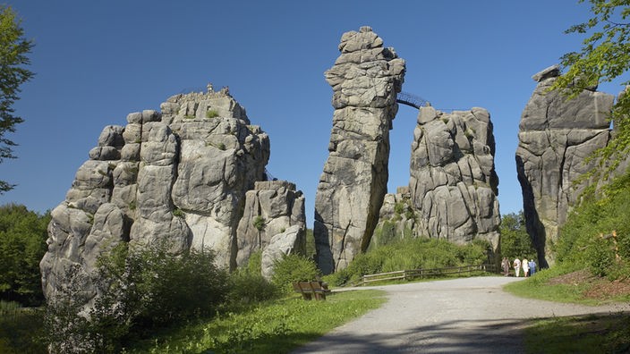 Eine distinkte Felsformation vor blauem Himmel: die Externsteine im Teutoburger Wald.